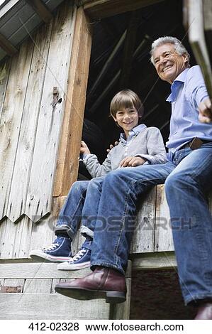 Stock Photo - Man and grandson sitting in doorway. Fotosearch