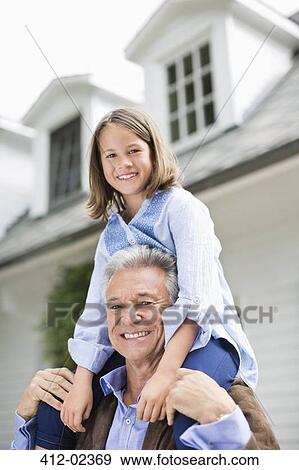 Man carrying granddaughter on shoulder outdoors View Large Photo Image Stock Photo - Man carrying granddaughter on shoulder outdoors. Fotosearch