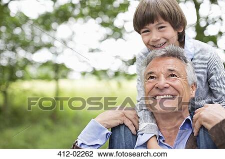 Man carrying grandson on his shoulders View Large Photo Image Stock Image - Man carrying grandson on his shoulders. Fotosearch