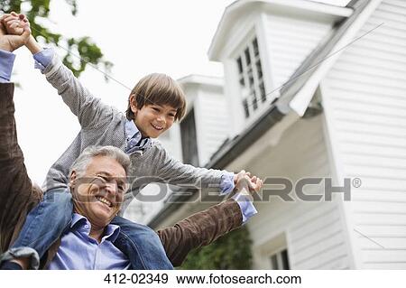 Man carrying grandson on shoulders outdoors View Large Photo Image Stock Photo - Man carrying grandson on shoulders outdoors. Fotosearch