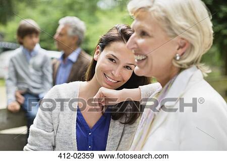 Stock Photo - Mother and daughter smiling together outdoors. Fotosearch
