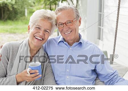 Smiling couple sitting on porch swing View Large Photo Image Stock Photography - Smiling couple sitting on porch swing. Fotosearch