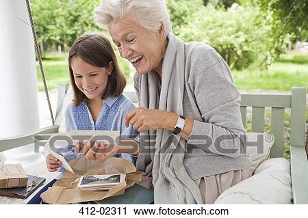 Woman and granddaughter looking at photos View Large Photo Image Stock Image - Woman and granddaughter looking at photos. Fotosearch