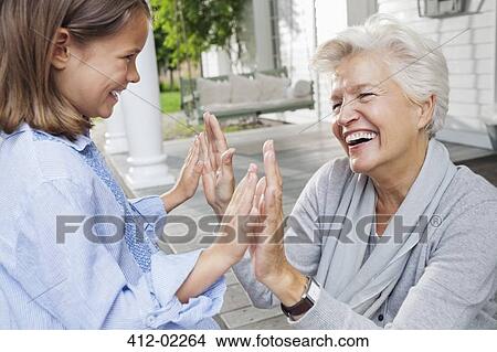 Woman and granddaughter playing clapping game View Large Photo Image Picture - Woman and granddaughter playing clapping game. Fotosearch