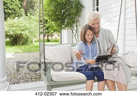 Woman and granddaughter reading on porch swing View Large Photo Image Stock Photo - Woman and granddaughter reading on porch swing. Fotosearch
