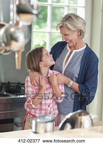 Woman and granddaughter smiling in kitchen View Large Photo Image Stock Photo - Woman and granddaughter smiling in kitchen. Fotosearch