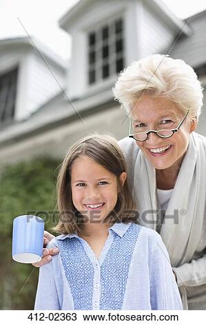 Woman and granddaughter smiling together outdoors View Large Photo Image Stock Image - Woman and granddaughter smiling together outdoors. Fotosearch