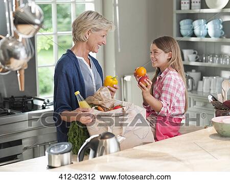 Woman and granddaughter unloading groceries View Large Photo Image Stock Image - Woman and granddaughter unloading groceries. Fotosearch