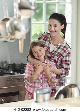 Woman hugging daughter in kitchen View Large Photo Image Stock Image - Woman hugging daughter in kitchen. Fotosearch