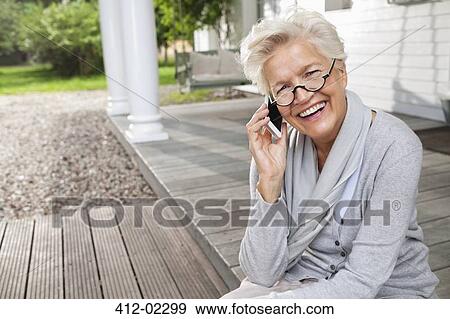 Woman talking on cell phone on porch View Large Photo Image Stock Photo - Woman talking on cell phone on porch. Fotosearch