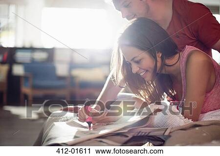 Couple reading newspaper together on bed View Large Photo Image Stock Image - Couple reading newspaper together on bed. Fotosearch