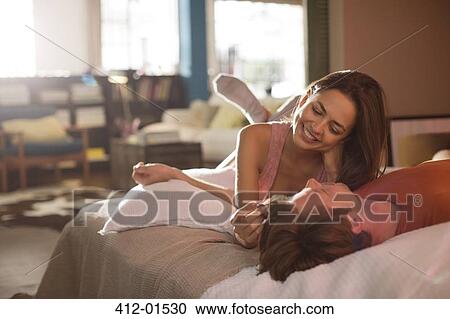 Stock Image - Couple relaxing on bed together. Fotosearch