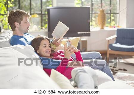 Couple relaxing on sofa together View Large Photo Image Picture - Couple relaxing on sofa together. Fotosearch
