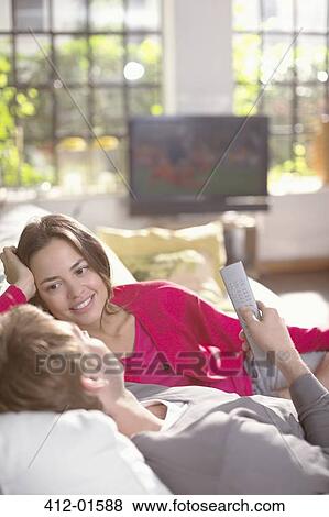 Couple relaxing together on sofa View Large Photo Image Stock Photo - Couple relaxing together on sofa. Fotosearch