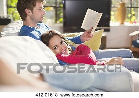 Couple relaxing together on sofa View Large Photo Image Stock Photo - Couple relaxing together on sofa. Fotosearch