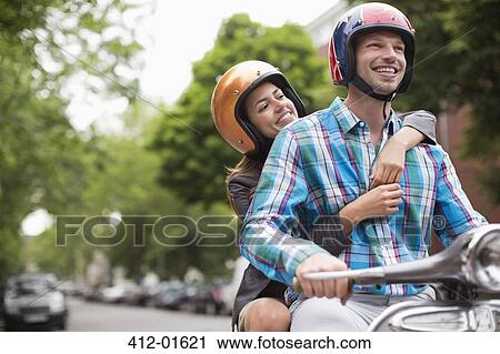 Couple riding scooter together outdoors View Large Photo Image Stock Image - Couple riding scooter together outdoors. Fotosearch