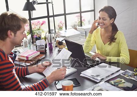 Couple working together at desk View Large Photo Image Stock Photo - Couple working together at desk. Fotosearch