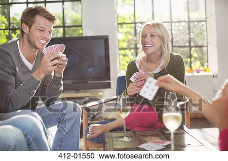 Friends playing card game in living room View Large Photo Image Stock Image - Friends playing card game in living room. Fotosearch