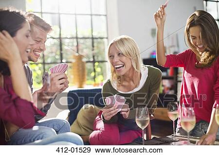 Friends playing card game in living room View Large Photo Image Stock Photo - Friends playing card game in living room. Fotosearch