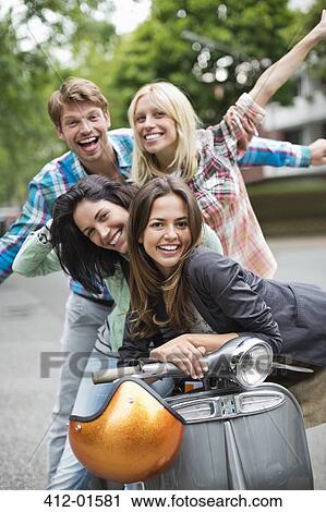 Friends smiling on scooter outdoors View Large Photo Image Stock Image - Friends smiling on scooter outdoors. Fotosearch