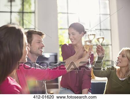 Stock Image - Friends toasting each other with wine. Fotosearch