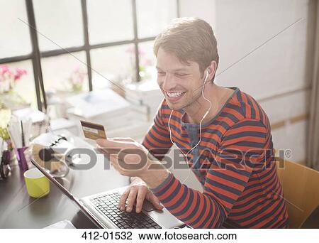 Man in headphones shopping on laptop View Large Photo Image Stock Image - Man in headphones shopping on laptop. Fotosearch