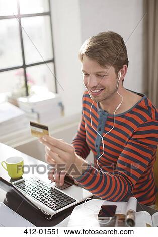 Man in headphones shopping on laptop View Large Photo Image Stock Image - Man in headphones shopping on laptop. Fotosearch