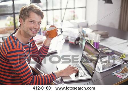 Man using laptop with cup of coffee View Large Photo Image Stock Image - Man using laptop with cup of coffee. Fotosearch