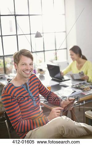 Smiling man using digital tablet View Large Photo Image Stock Photography - Smiling man using digital tablet. Fotosearch
