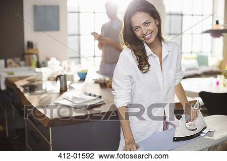 Smiling woman ironing in kitchen View Large Photo Image Stock Image - Smiling woman ironing in kitchen. Fotosearch