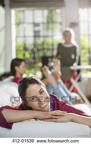 Smiling woman relaxing on sofa View Large Photo Image Stock Photo - Smiling woman relaxing on sofa. Fotosearch