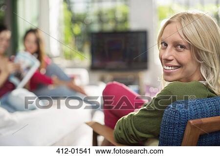 Smiling woman sitting in armchair View Large Photo Image Stock Image - Smiling woman sitting in armchair. Fotosearch