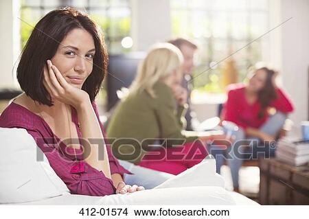 Smiling woman sitting on sofa View Large Photo Image Picture - Smiling woman sitting on sofa. Fotosearch
