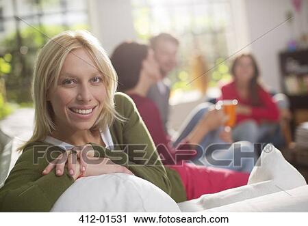 Smiling woman sitting on sofa View Large Photo Image Stock Image - Smiling woman sitting on sofa. Fotosearch