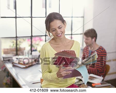 Stock Photo - Woman looking at fabric swatches. Fotosearch