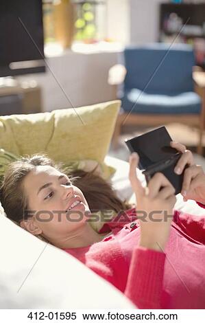 Woman playing video games on sofa View Large Photo Image Stock Photography - Woman playing video games on sofa. Fotosearch