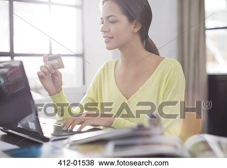 Stock Photo - Woman shopping on laptop. Fotosearch