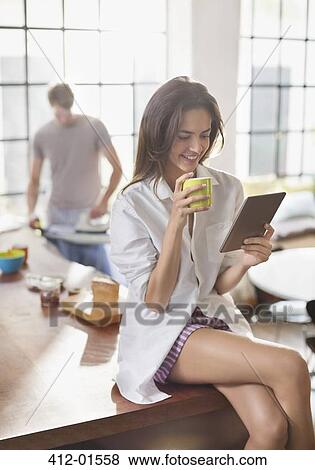 Woman using digital tablet in kitchen View Large Photo Image Stock Photo - Woman using digital tablet in kitchen. Fotosearch