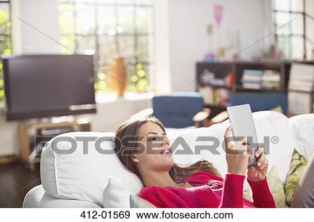 Stock Photo - Woman using digital tablet on bed. Fotosearch