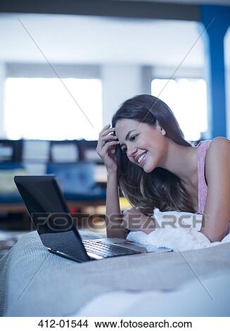 Woman using laptop on bed View Large Photo Image Picture - Woman using laptop on bed. Fotosearch
