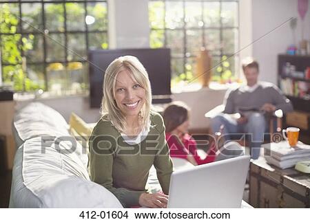 Woman using laptop on sofa View Large Photo Image Picture - Woman using laptop on sofa. Fotosearch