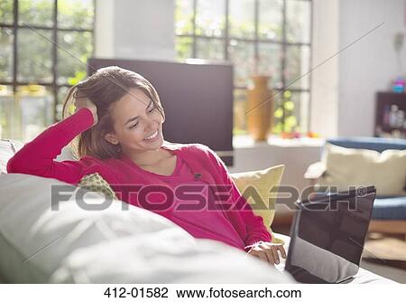 Woman using laptop on sofa View Large Photo Image Stock Image - Woman using laptop on sofa. Fotosearch