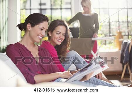 Women reading magazine together on sofa View Large Photo Image Stock Photography - Women reading magazine together on sofa. Fotosearch