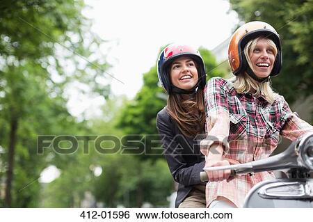 Women riding on scooter together outdoors View Large Photo Image Stock Photograph - Women riding on scooter together outdoors. Fotosearch
