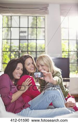 Women taking pictures together on sofa View Large Photo Image Stock Image - Women taking pictures together on sofa. Fotosearch