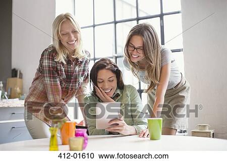 Women using digital tablet together View Large Photo Image Stock Image - Women using digital tablet together. Fotosearch