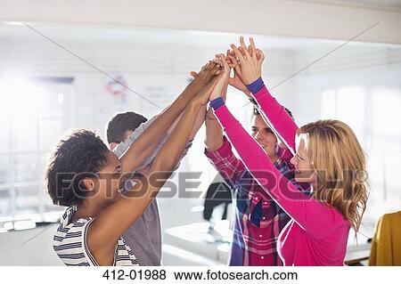 Stock Photo - Business people cheering together in office. Fotosearch