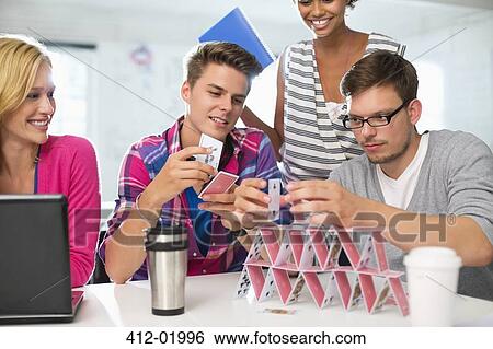 Stock Photograph - Business people making house of cards in office. Fotosearch