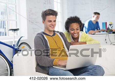 Stock Photograph - Business people using laptop in office. Fotosearch
