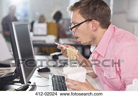 Businessman eating Chinese food at desk View Large Photo Image Picture - Businessman eating Chinese food at desk. Fotosearch